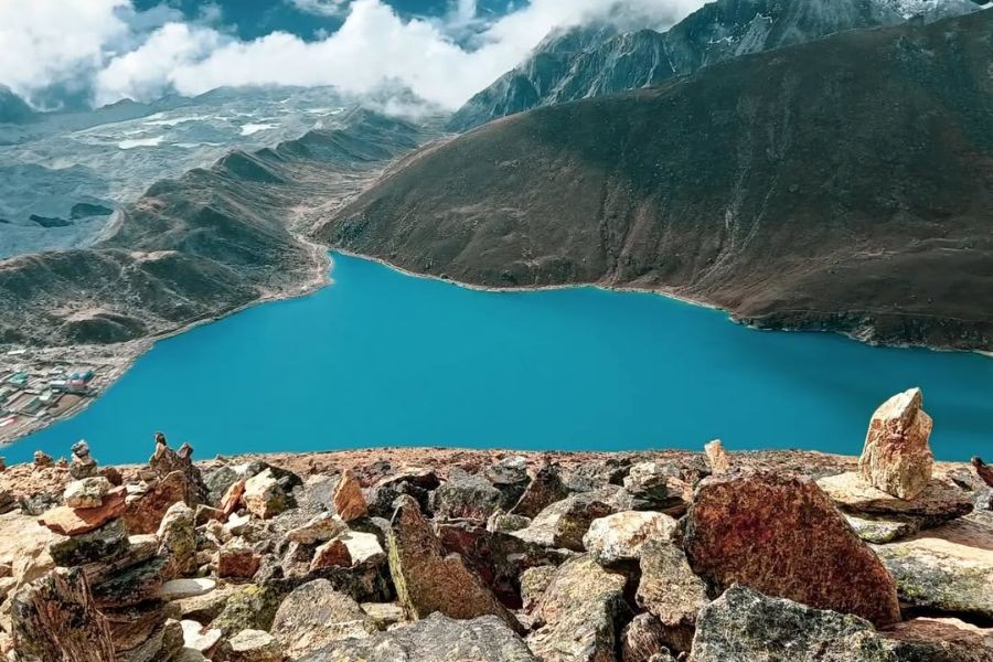 Gokyo Lake's brilliant turquoise water with glacier and mountains in background